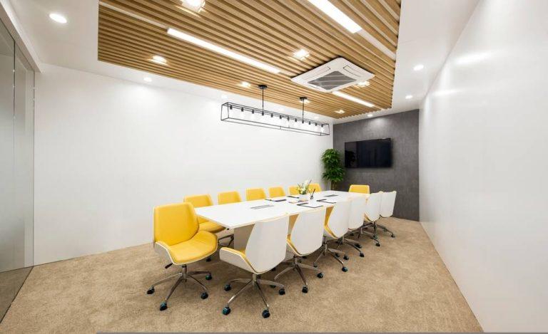Modern boardroom furniture in Essex with ergonomic chairs, white meeting table, and acoustic ceiling design
