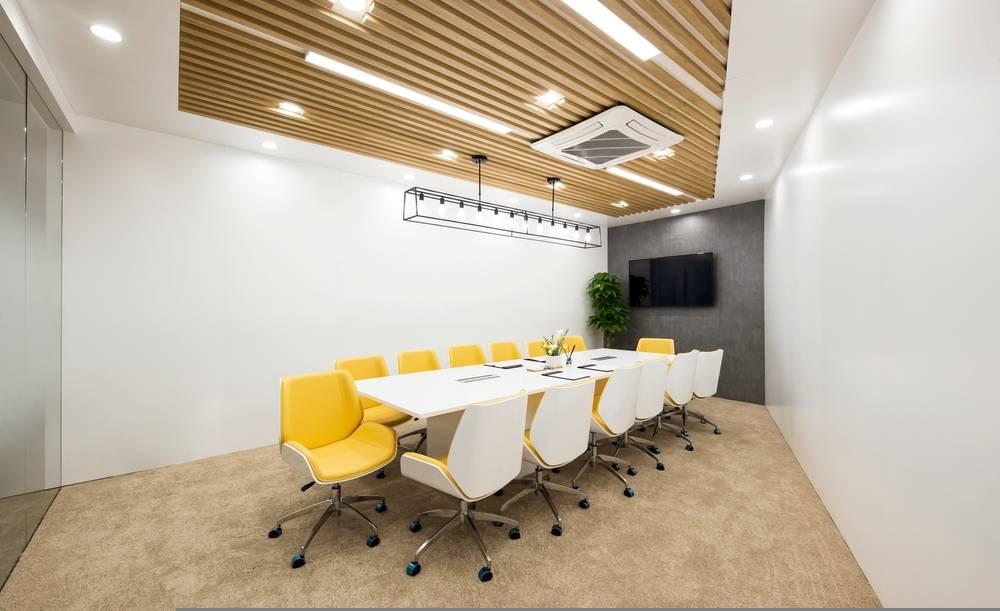 Modern boardroom furniture in Essex with ergonomic chairs, white meeting table, and acoustic ceiling design