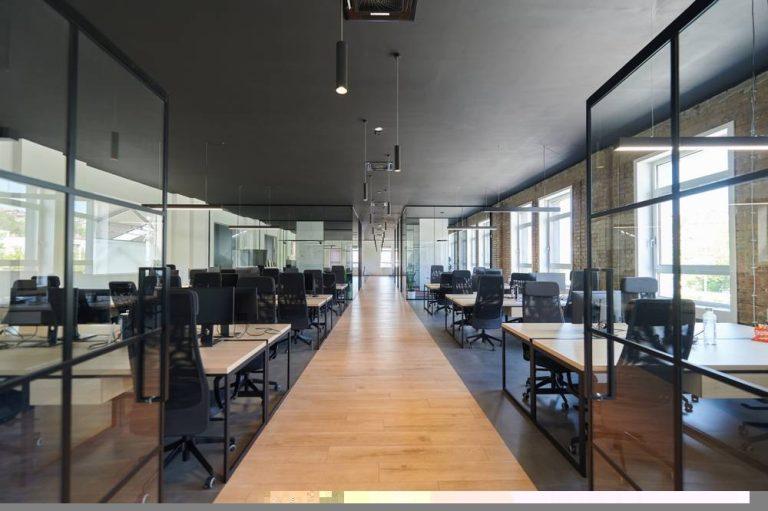 Modern office design in Essex featuring glass partitions, ergonomic desks, and open-plan layout