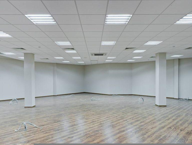 Empty office space in Essex after refit works with new lighting, ceiling tiles, and wood-effect flooring installed